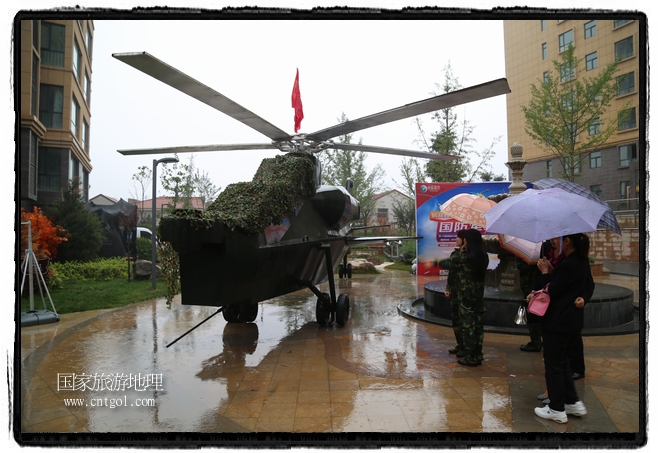 小區(qū)突然出現(xiàn)“飛機坦克”，其中殲15艦載戰(zhàn)斗機一架、99式主戰(zhàn)坦克一輛、武直-10武裝直升機一架，吸引了眾多市民雨中圍觀、合影。